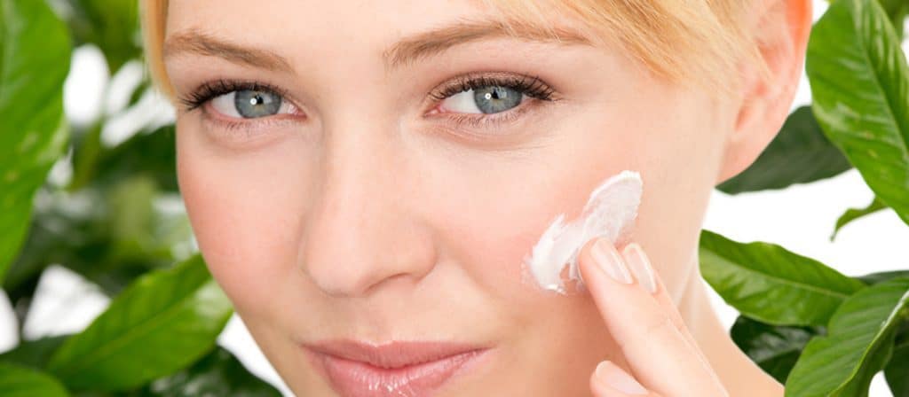 woman applying skincare products to her face